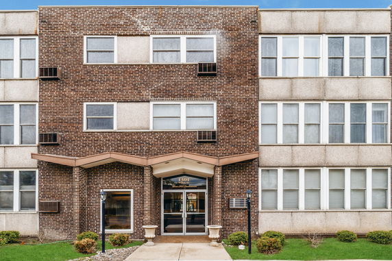 Front view of a multi-story brick building with a central entrance.