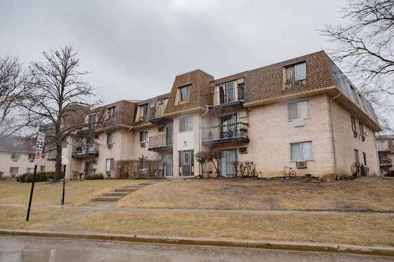 Front view of a three-story residential building with balconies.