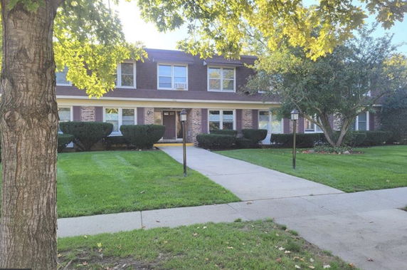 Front view of a two-story residential building with a walkway