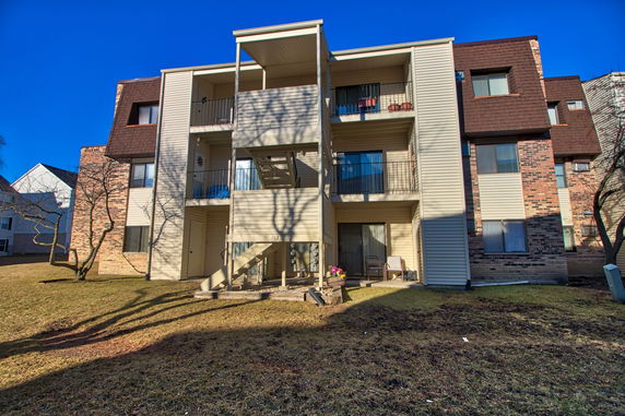 Front view of a multi-story apartment building with balconies and staircases.