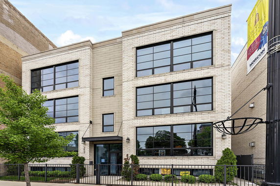Front view of a multi-story building with large windows.
