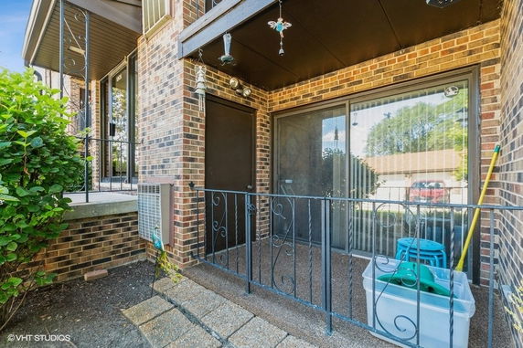 Front view of a brick exterior with sliding glass door and small balcony.