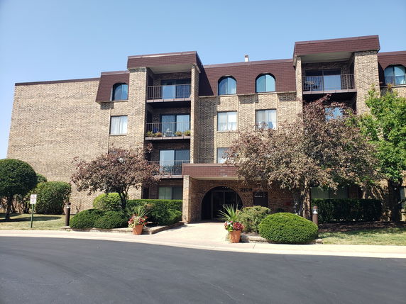 Front view of a multi-story brick building with balconies.