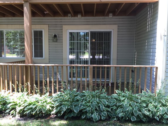 Front view of a house with a small porch and railing.