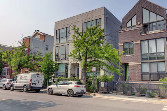 Front view of a modern multi-story building with large windows.