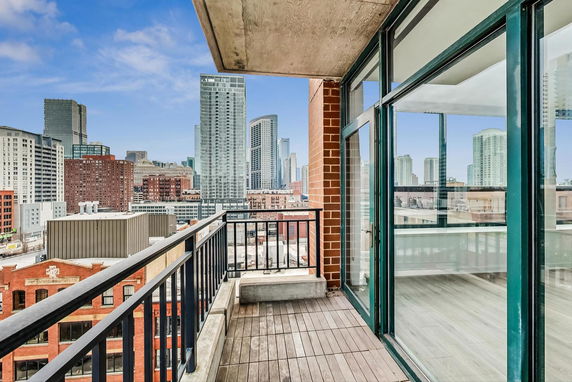 View from a balcony overlooking a cityscape with tall buildings.