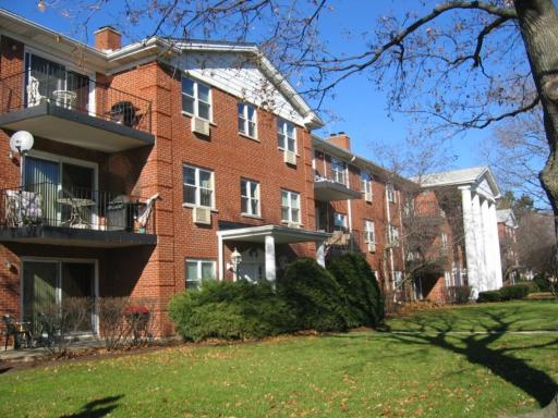 Front view of a multi-story brick apartment building with balconies.
