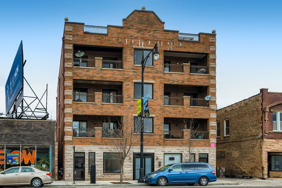 Front view of a multi-story brick building with balconies.