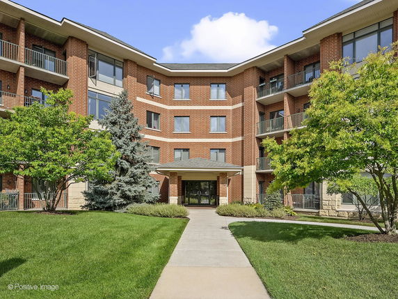 Front view of a multi-story building with a brick facade and balconies.