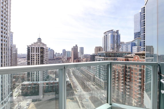 A panoramic view of city buildings from a modern balcony perspective.