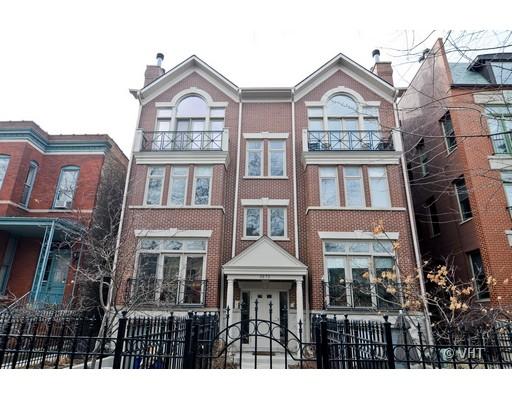 Front view of a three-story brick residential building with multiple windows and small balconies.