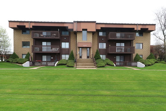 Front view of a multi-story apartment building with balconies.