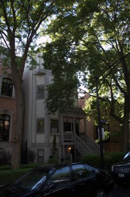 Front view of a multi-story house with a porch and staircase.