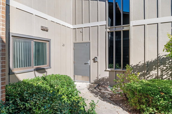 Front view of a building with a metal door and windows.