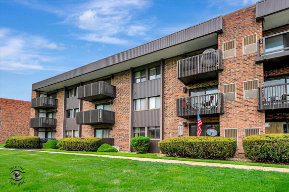 Front view of a multi-story apartment building with balconies.