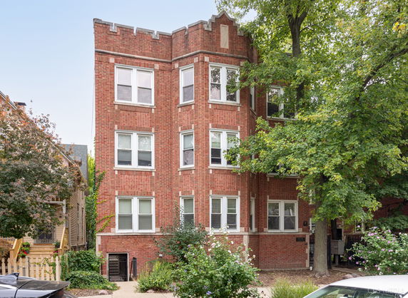 Front view of a multi-story brick building with multiple windows.