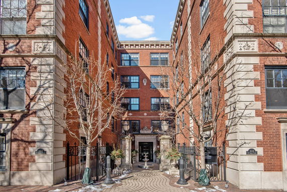 Front view of a multi-story brick building with decorative stone trim.