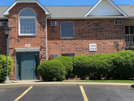 Front view of a brick two-story building with a central entrance.