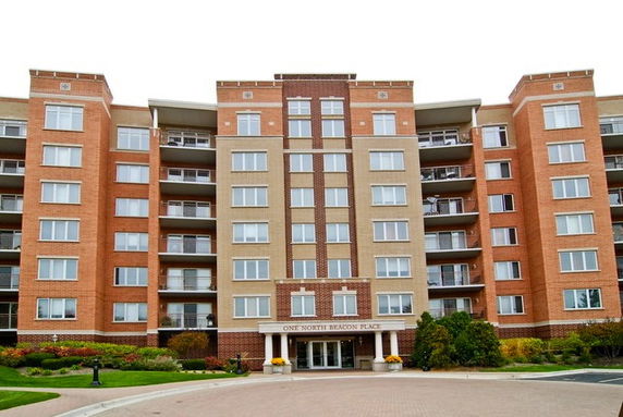 Front view of a multi-story apartment building with multiple balconies.