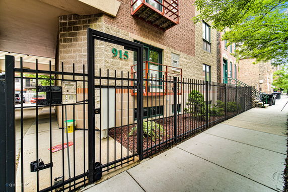 Front view of a brick multi-story building with a gated entrance.
