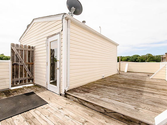 Rooftop with a small structure and a satellite dish.