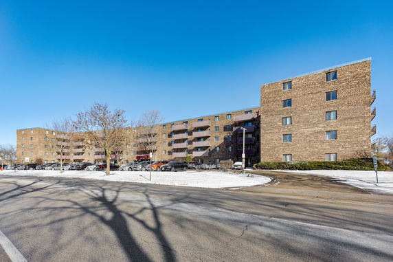 Front view of a multi-story brick apartment building.