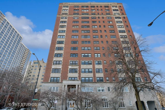 Front view of a multi-story brick building with large windows.