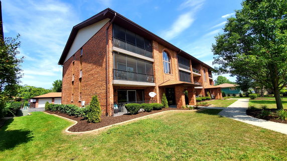 Front view of a two-story brick apartment building with balconies.