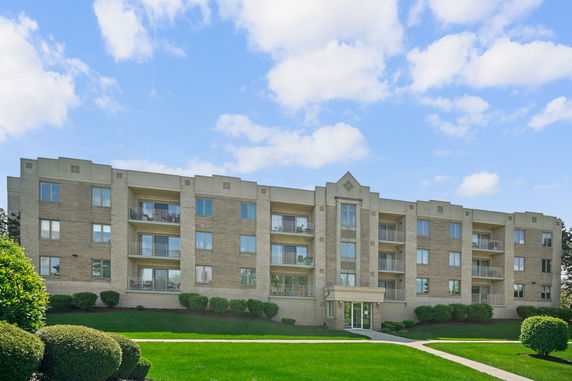 Front view of a multi-story apartment building with balconies.