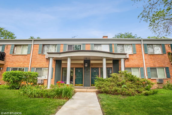 Front view of a two-story brick building with a columned entrance.
