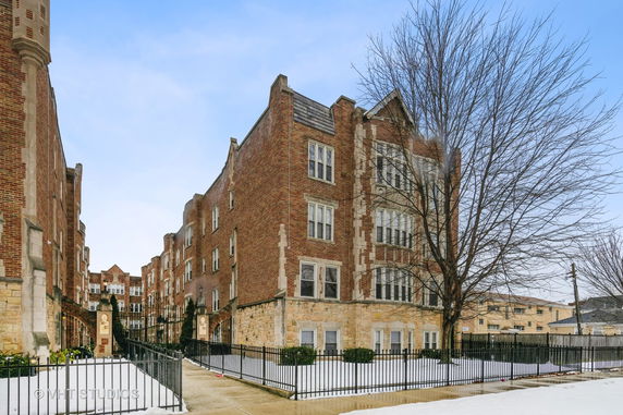 Front view of a multi-story brick building with architectural details and large windows.