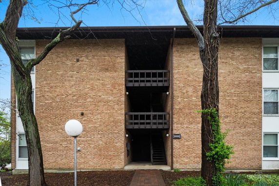 Front view of a multi-story brick building with stair access.