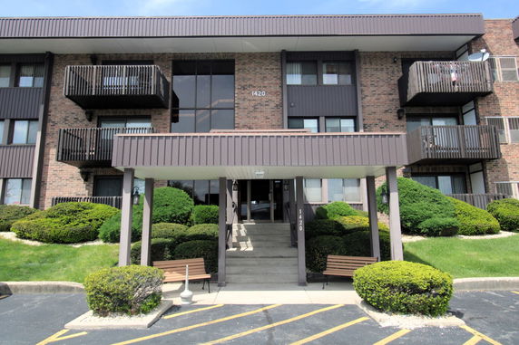 Front view of a multi-story apartment building with balconies.