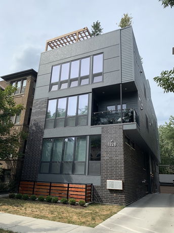 Front view of a modern multi-story house with large windows.