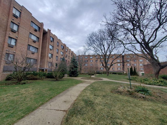 Front view of a multi-story brick building with multiple windows.