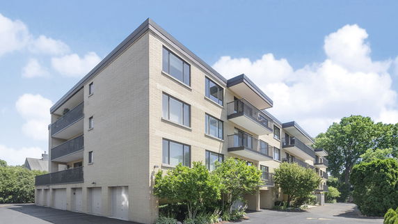Front view of a multi-story apartment building with multiple balconies.
