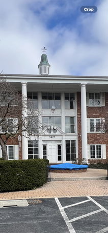 Front view of a multi-story building with large columns and a cupola.