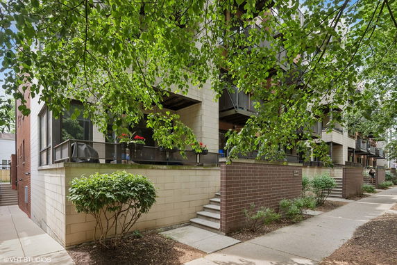 Front view of a multi-story building with balconies and brick exterior.