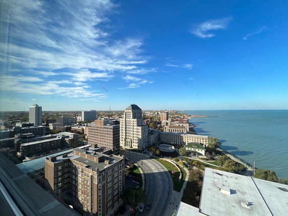 Panoramic view of a cityscape with multiple buildings and a waterfront.
