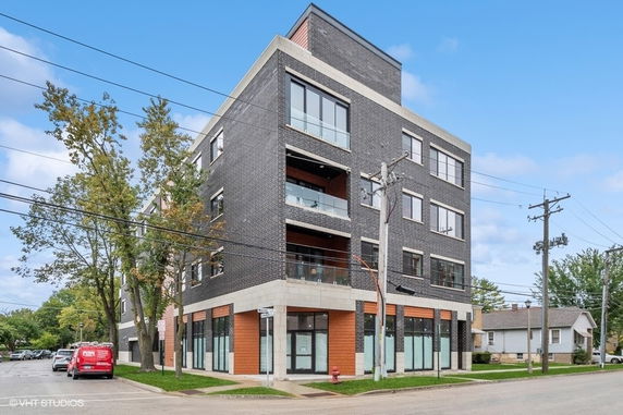 Front view of a multi-story commercial building with large windows and balconies.
