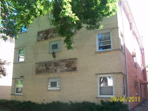 Front view of a multi-story brick building with multiple windows.
