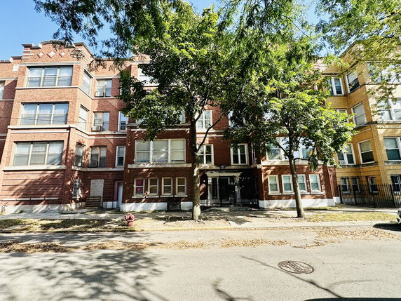 Front view of a multi-story brick apartment building.