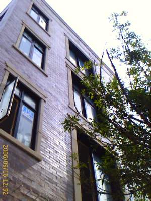 Front view of a multi-story brick building with multiple windows.