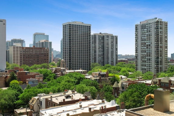 Panoramic view of city buildings and greenery from a high vantage point.