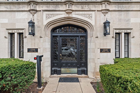Entrance of a building with ornate black door and exterior stonework.