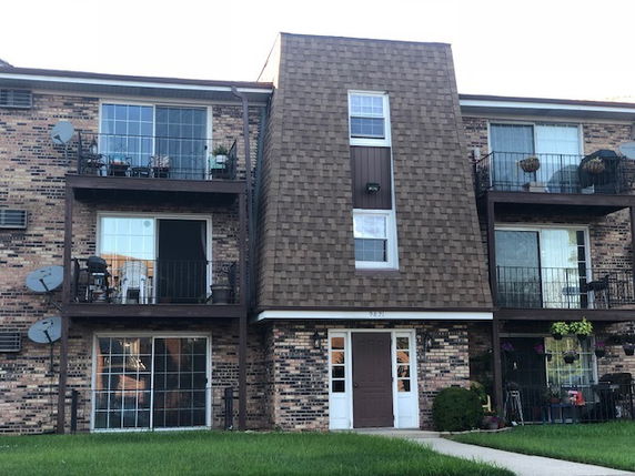 Front view of a multi-story residential building with balconies.