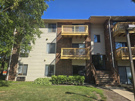 Front view of a multi-story apartment building with balconies.