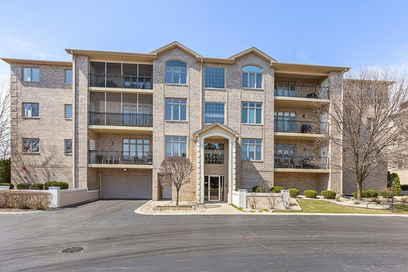 Front view of a multi-story apartment building with balconies.