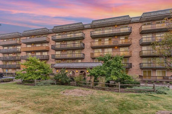 Front view of a multi-story apartment building with balconies.