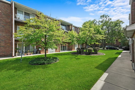 Front view of a multi-story brick apartment building with balconies.